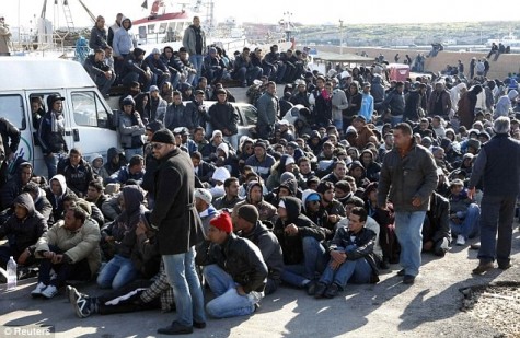 Italian Coast Guard rescued some a boatload of migrants off Lampedusa. Photo via Daily Mail under the Creative Commons license (http://www.dailymail.co.uk/news/article-1356571/Tunisia-unrest-Italys-state-emergency-4-000-illegal-immigrants-arrive-4-days.html) 