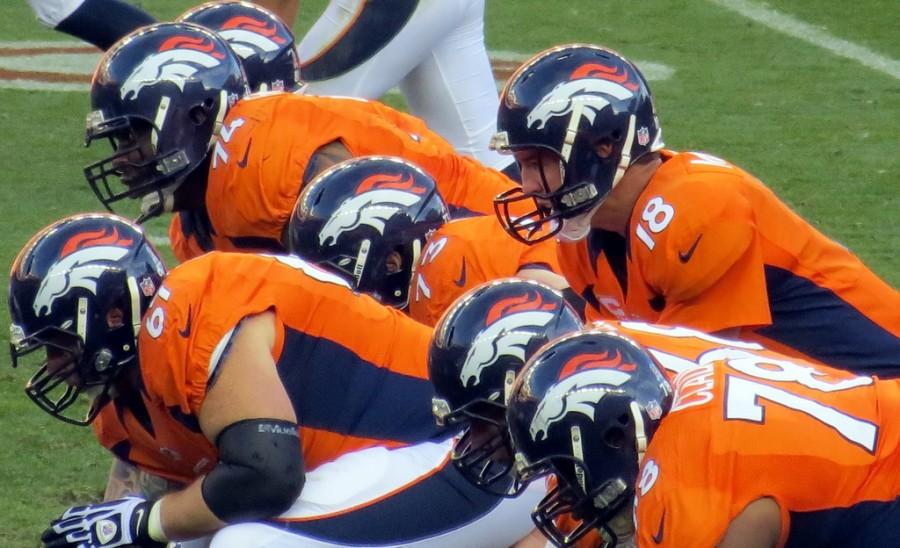 Peyton Manning and the Broncos offensive line get ready for a play. Photo via Flickr.com under the Creative Commons license. https://www.flickr.com%2Fservices%2Ffeeds%2Fgeo%2F%3Fformat%3Dkml%26tags%3Dchampbailey%26lang%3Den-us%26page%3D1&psig=AFQjCNHKvTVAfJwfDRdz4Xcl--1EXnYRYQ&ust=1442506696038262