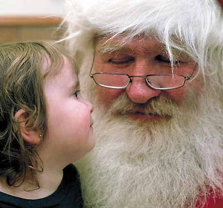 Riley Whelan, 2, and Larry Geiger as Santa contemplate eachother last week at the United Way office.