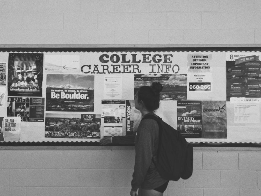 AAHS senior Nicole Lindsey standing in front of the student and services college wall, pondering the future decisions of college. 