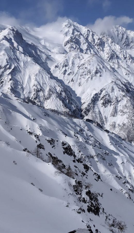 A snow-filled mountain range shows the potential for fun but also danger due to avalanche risks.