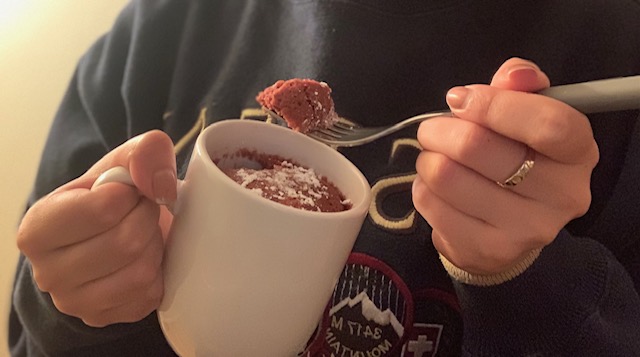 Sophomore Deanna Ponce poses with a red velvet mug cake with powdered sugar on top.