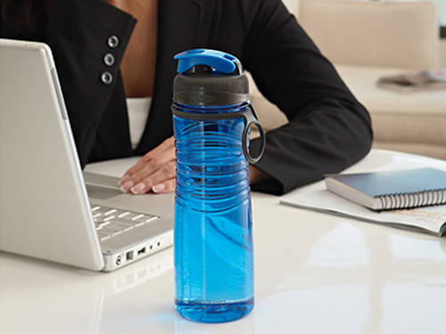 A water bottle sits ready for use behind a computer. Labeled for Reuse under the Creative Commons