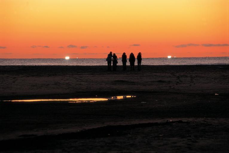 Friends enjoy a summer night on the beach. Licensed for Creative Commons. 
