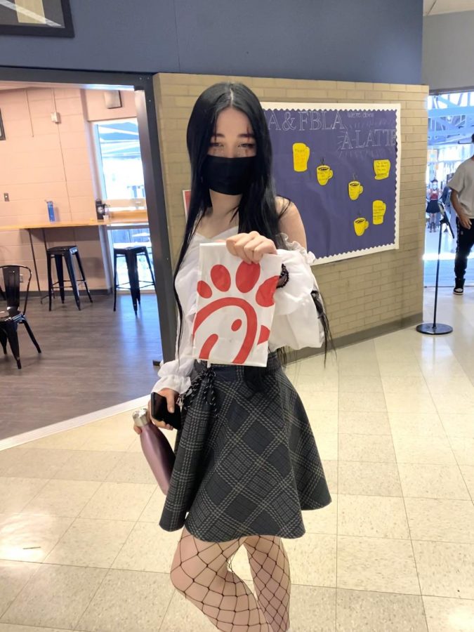 Junior Lily Wong posing by the cafeteria with her Chick-Fil-A.