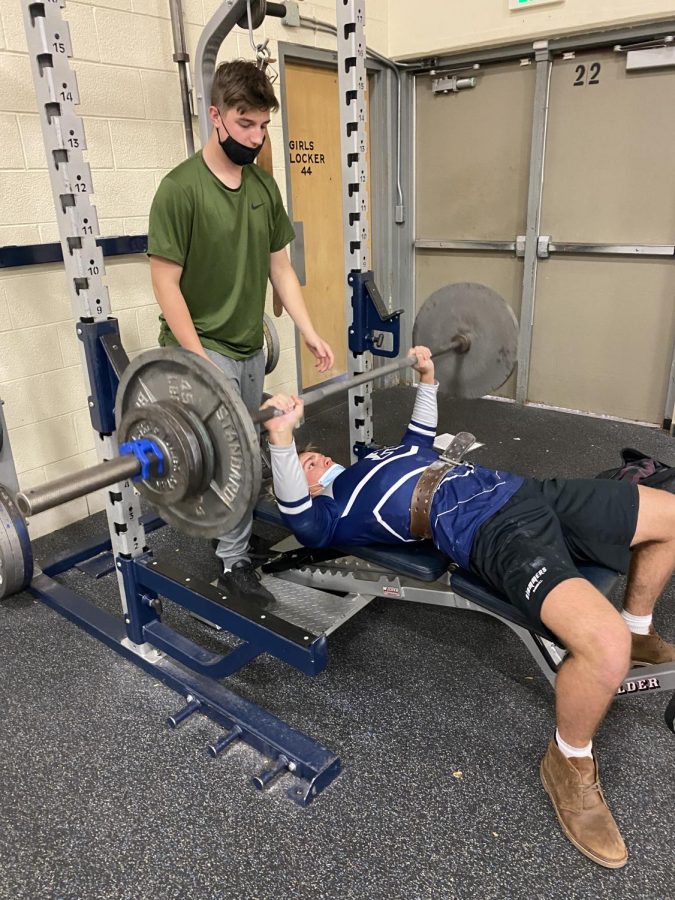 Senior+James+Wright+Benching+205+Ibs+in+the+AAHS+Weight+room%2C+while+being+spotted+by+junior+Tristan+Hollman.+