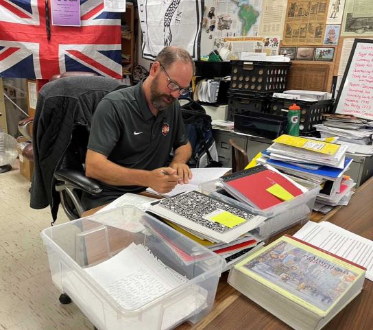 Social studies teacher, Ronald Gorr, grading notebooks for AP U.S. History during KAT time. 