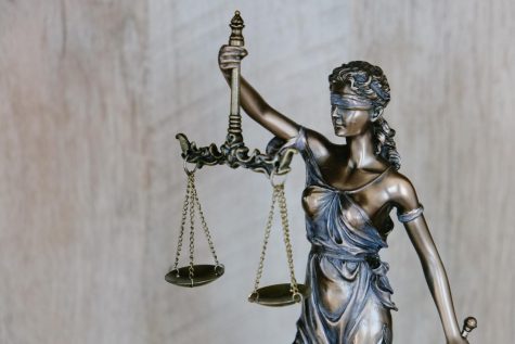 Lady Justice graciously holds the scales which represents the courts fair judgement. Labeled free for reuse by Unsplash.