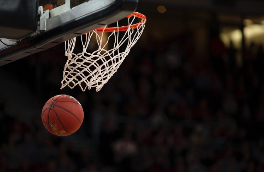 A basketball going into a hoop, indicating a point. Free image from Unsplash.