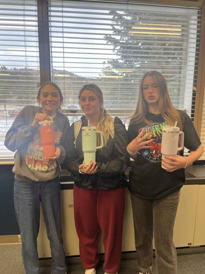 Sophomore Liza Clark, (far left), senior Bree Mason (middle) and junior Ally Collins (far right) show off their Stanley Cups to student council and all they have to offer for other students. 