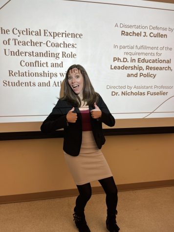 Dr. Rachel Cullen happily posing in front of her dissertation at the University of Colorado Colorado Springs on March 16th 2023!