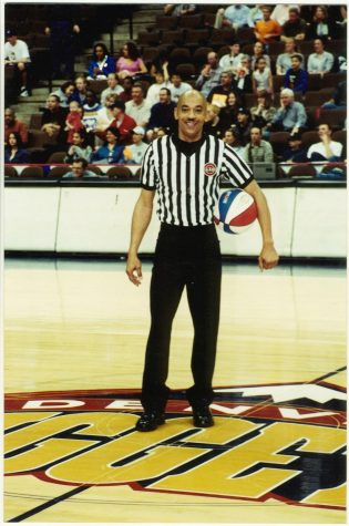 Pictured is referee Bill Cooper standing and posing with  basketball in hand at the Ball Arena in Denver.