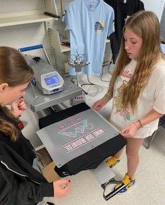 Sophomore Addison Kipp and sophomore Riley Green help contribute to the process of making the t-shirts for Kadet Enterprises. 