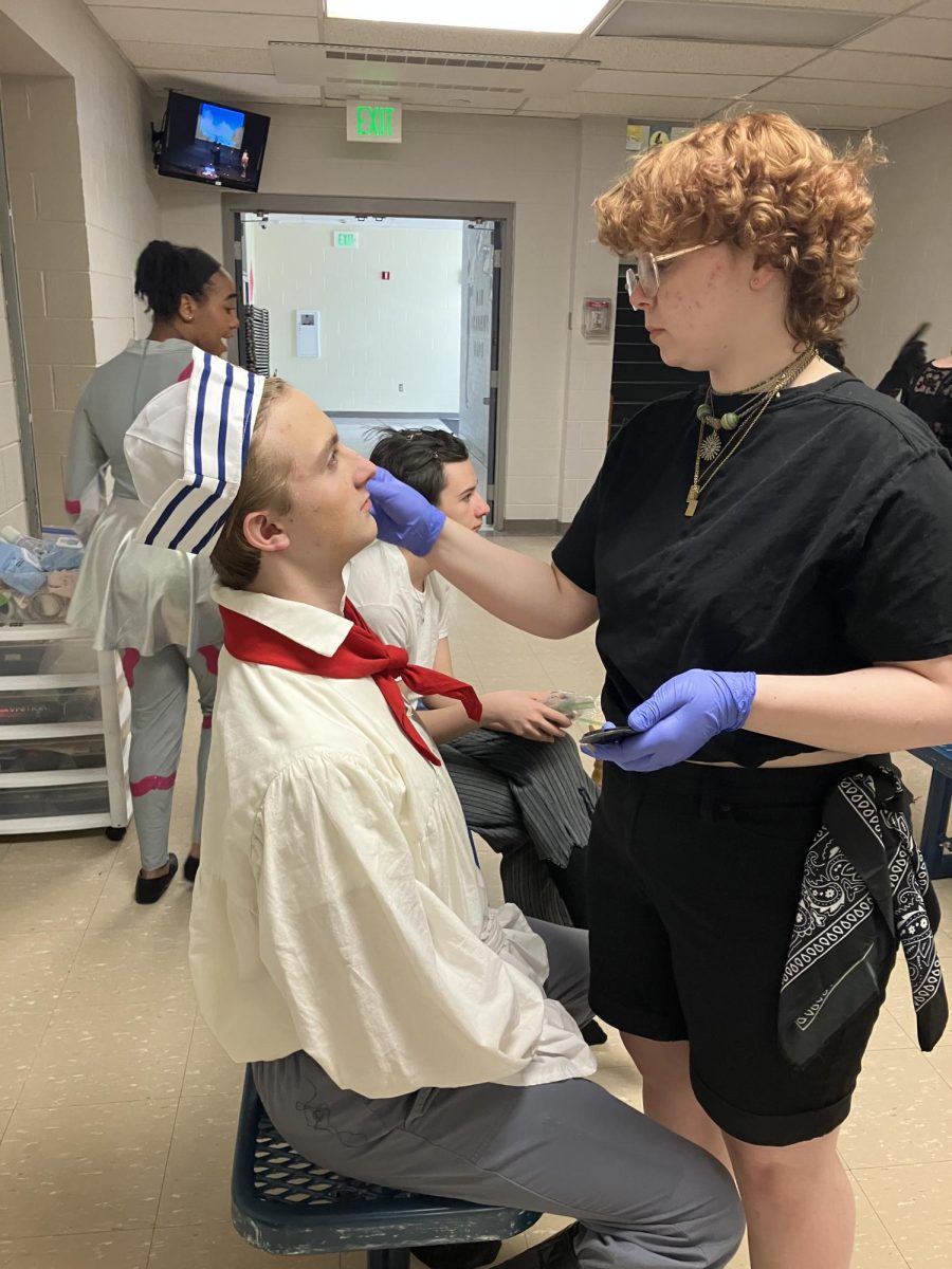 Tech crew prepares for opening night at their dress rehearsal. Senior Will Lamb (right) applies makeup on freshman Finn Richie before his stage cue. 